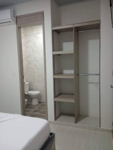 a bedroom with a bed and a bathroom with a toilet at hotel brb nature acacias in Acacías