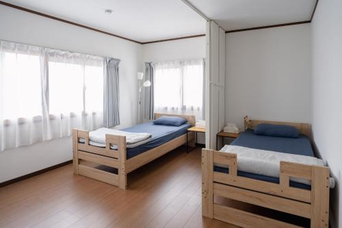 two twin beds in a room with windows at Kaga Travel - Hakusandai, Whole building for rent in Kaga