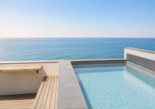 a swimming pool with the ocean in the background at Casa do Sol by Amazing Madeira in Jardim do Mar