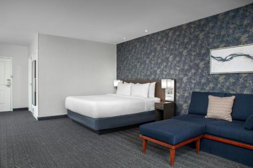 a hotel room with a bed and a couch at Courtyard by Marriott Richmond Downtown in Richmond