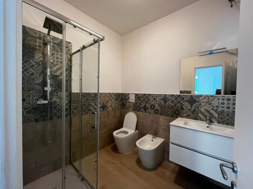 a bathroom with a shower and a toilet and a sink at Bigò Apartments in Termoli