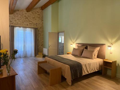 a bedroom with a large bed and a window at Moulin de Carrière, dans un parc de 2 hectares à Uzès in Uzès