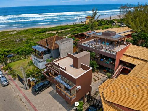 an aerial view of a house next to the beach at Residencial La Ferrugem - Garopaba/SC in Garopaba