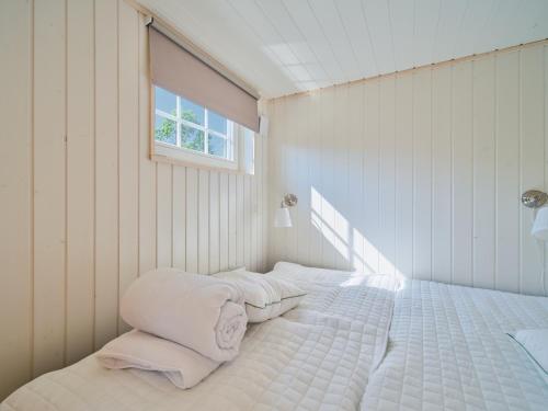 a bedroom with a bed with two pillows and a window at Lakeside Herrestad in Värnamo
