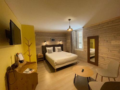 a hotel room with a bed and a table at La chaumette in Pannessières