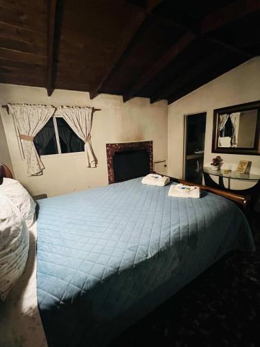 a bedroom with a large bed with blue sheets at Rancho Meling in Camalú