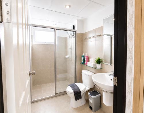 a bathroom with a shower and a toilet and a sink at Modern 12th Floor Condo Walk to Phuket Old Town with Pool & Gym in Phuket