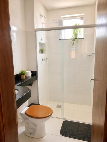 a bathroom with a toilet and a glass shower at Cantinho Xodó in Capitólio