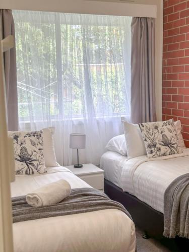 a bedroom with two beds and a window at Cozy & Spacious Family Unit Mt Martha in Mount Martha