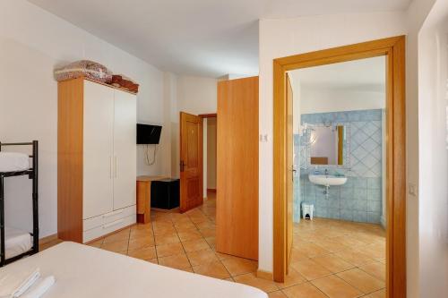 ein Zimmer mit einem Badezimmer mit Waschbecken und Spiegel in der Unterkunft Nurache in Orosei