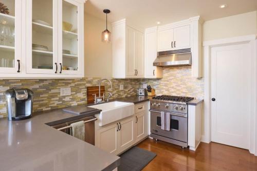a kitchen with white cabinets and a sink and a stove at Playa One Bedroom (253) in Carpinteria