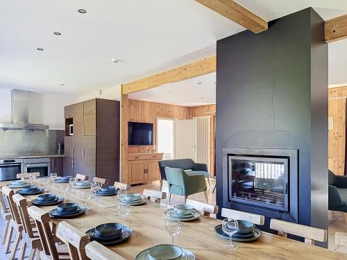 a dining room with a long table and a fireplace at Le Refuge du Trappeur in Hour
