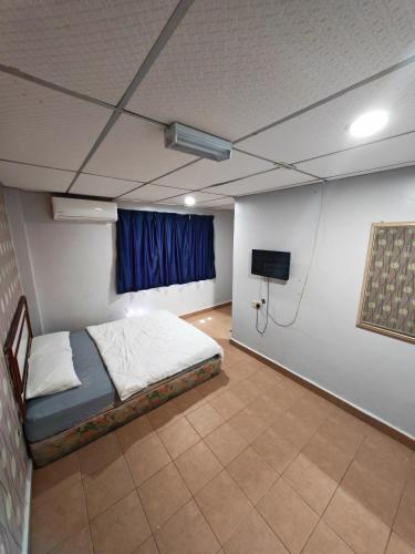 a room with a bed and a tv in it at Shakim hotel in Cukai