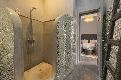 a bathroom with a shower with a glass enclosure at Riad Origines in Marrakesh