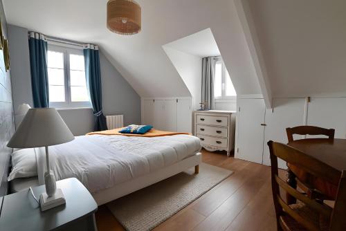 a bedroom with a bed and a desk and windows at Chambre d'hotes la Mainguy in Ruca