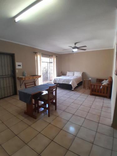 a bedroom with a bed and a table in a room at Ligema Lodge in Malelane