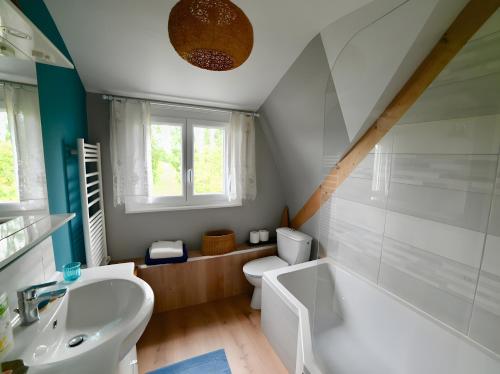 a bathroom with a white tub and a sink at Chambre d'hotes la Mainguy in Ruca