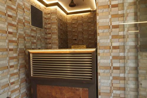a bathroom with a shower with a tiled wall at Hotel Malabar Plaza in Cochin