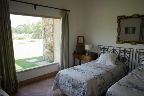 a bedroom with two beds and a large window at Finca El Ropero Eco-friendly house in Villanueva de la Vera