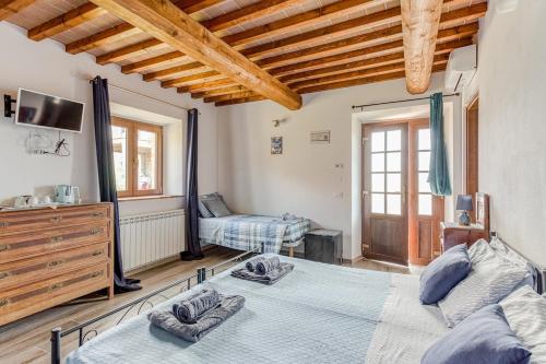 a bedroom with two beds in a room with wooden ceilings at La Quinta Decima Bioagriturismo in Fattoria Spedaletto
