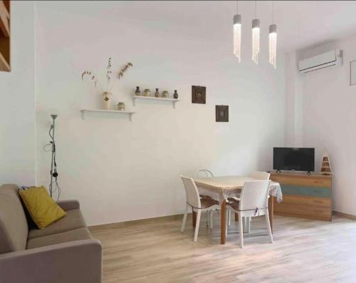 a living room with a table and chairs and a couch at Cielo e Mare in Scalea