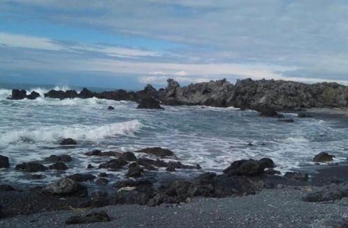 a beach with rocks and the ocean with waves at Cielo e Mare in Scalea