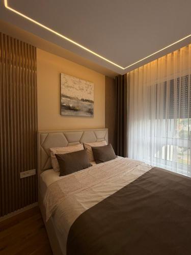 a bedroom with a large bed in front of a window at Emma Luksuzni apartman Tuzla Musique in Tuzla