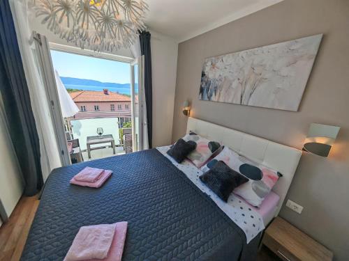 ein Schlafzimmer mit einem Bett und einem großen Fenster in der Unterkunft Villa Infinity in Krk