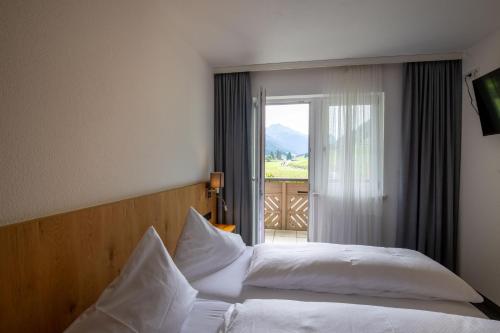 ein Schlafzimmer mit einem Bett mit weißer Bettwäsche und einem Fenster in der Unterkunft Klaushof in Ischgl