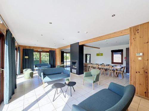 a living room with blue couches and a dining room at Le Refuge du Trappeur in Hour