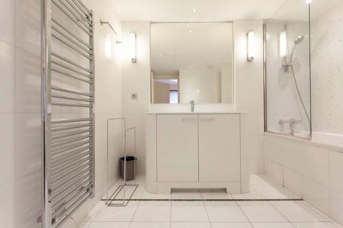 une salle de bain blanche avec une douche et un lavabo dans l'établissement Carlton Riviera Apartment, à Cannes