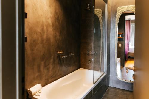 a bathroom with a bath tub and a mirror at Esplendor by Wyndham El Calafate in El Calafate