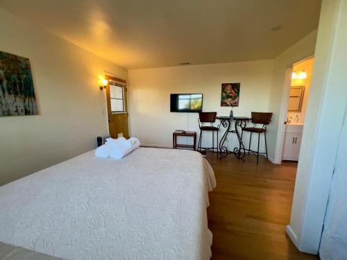 a bedroom with a bed and a table and chairs at Charming studio one mile from beach in Aptos