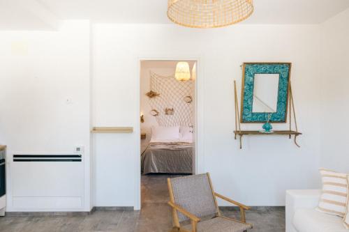 a living room with a chair and a mirror at Appartamento Sea - Tenuta Fascianello in Fasano