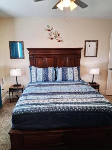 a bedroom with a bed with a wooden headboard and two lamps at Xscapecation Oasis III in Tulsa