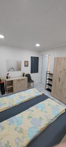 a room with two beds in a room with a sink at Тера Лакшъри Суит in Asenovgrad