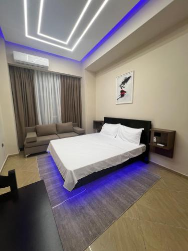 a bedroom with a bed and a couch at Skampa Apartment in Elbasan