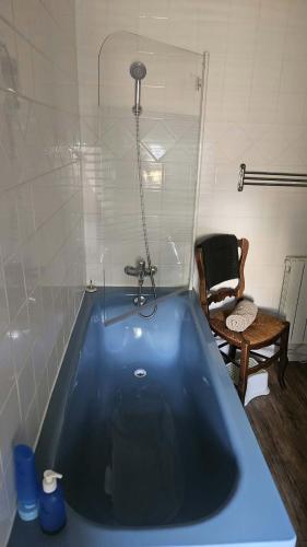 a blue bath tub in a room with a chair at Holy Cottage in Sainpuits