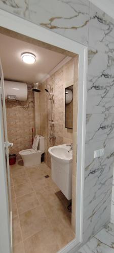 a bathroom with a white tub and a sink at Тера Лакшъри Суит in Asenovgrad