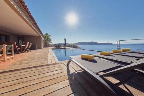 a swimming pool with a deck and the water at Cala Di Mare Villa in Calvi