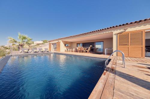 a swimming pool in front of a house at Cala Di Mare Villa in Calvi
