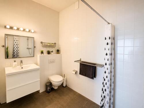 a white bathroom with a toilet and a sink at La tête dans les nuages - Chez Léa in Braine-lʼAlleud