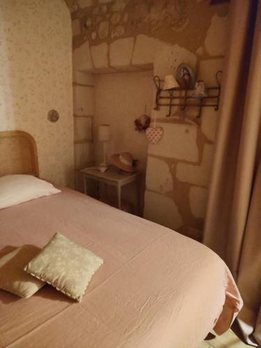 a bedroom with a bed and a table with a night stand at Le Logis Rabelaisien in Bourgueil