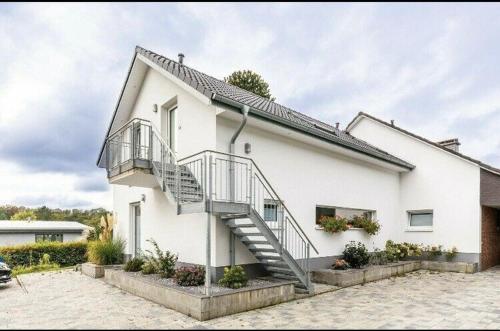 a white house with a staircase on the side of it at Ferienwohnung Grüner Weg in Tecklenburg
