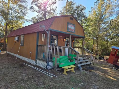 a small cabin with a bench in front of it at Whippowill Cabin in Moss Point