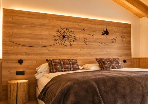 a bedroom with two beds and a wooden wall at B&B Te Nìf in Predazzo
