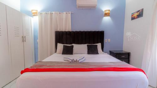 a bedroom with a large white bed with a black headboard at Villa Palacio Verde Las terrenas in Las Terrenas