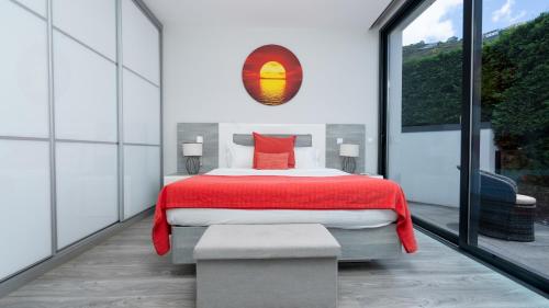 a bedroom with a bed with a red blanket at Villa Stella by LovelyStay in Arco da Calheta