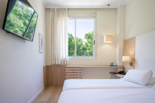 ein Hotelzimmer mit zwei Betten und einem Fenster in der Unterkunft Checkin Valencia Ciscar in Picanya