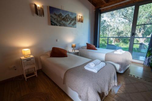 a bedroom with two beds and a window at Biovilla Sustentabilidade in Palmela